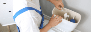 A plumber working on a toilet